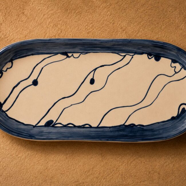 Handmade ceramic tray by Greek artist Aglaia Leoussi, decorated with blue abstract lines and organic shapes on white ceramic
