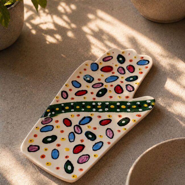 Happy Hands ceramic artwork by Greek artist Aglaia Leoussi, featuring a colorful hand-shaped sculpture with abstract painted patterns